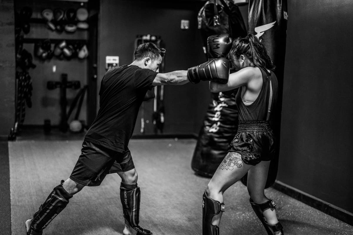My partner and I training muay thai in a gym.