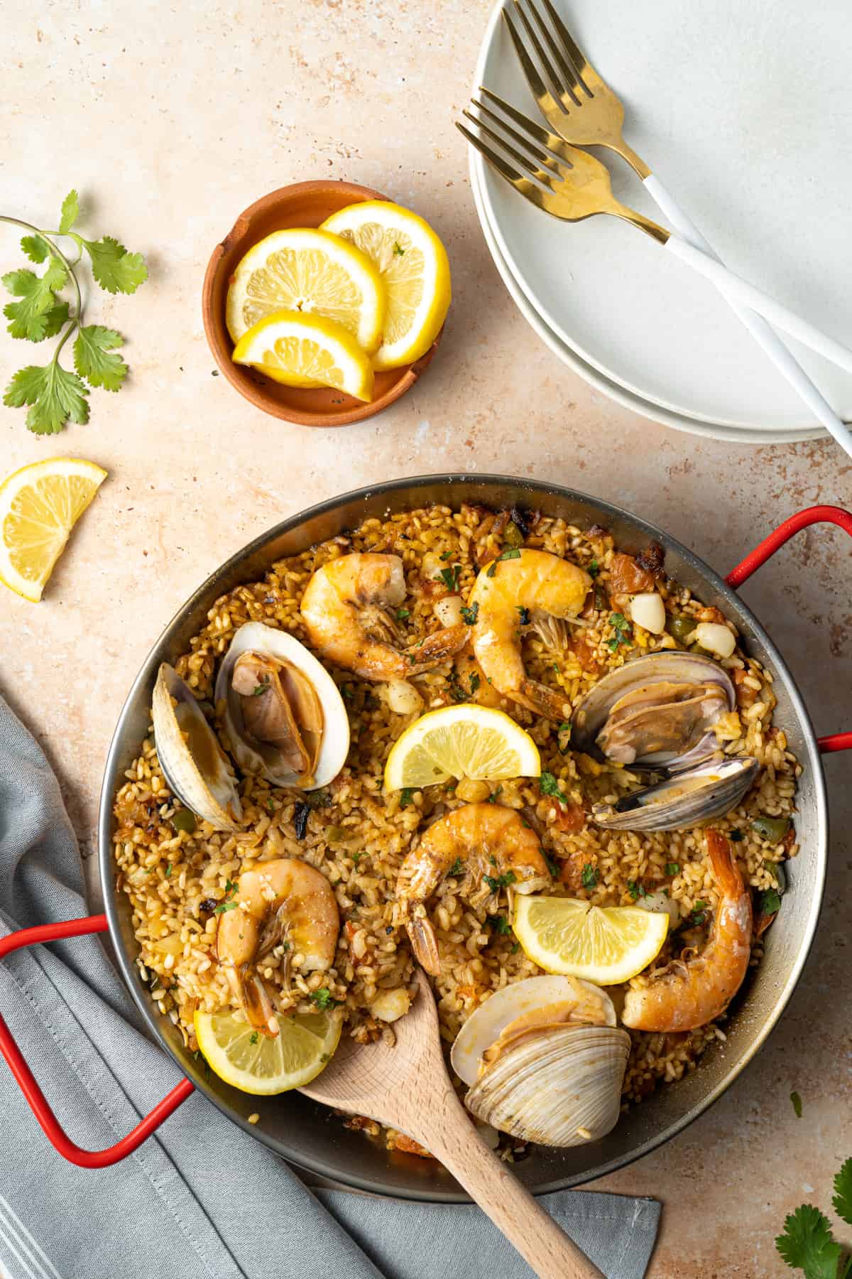 An overhead shot of seafood paella with a wooden spoon scooped.