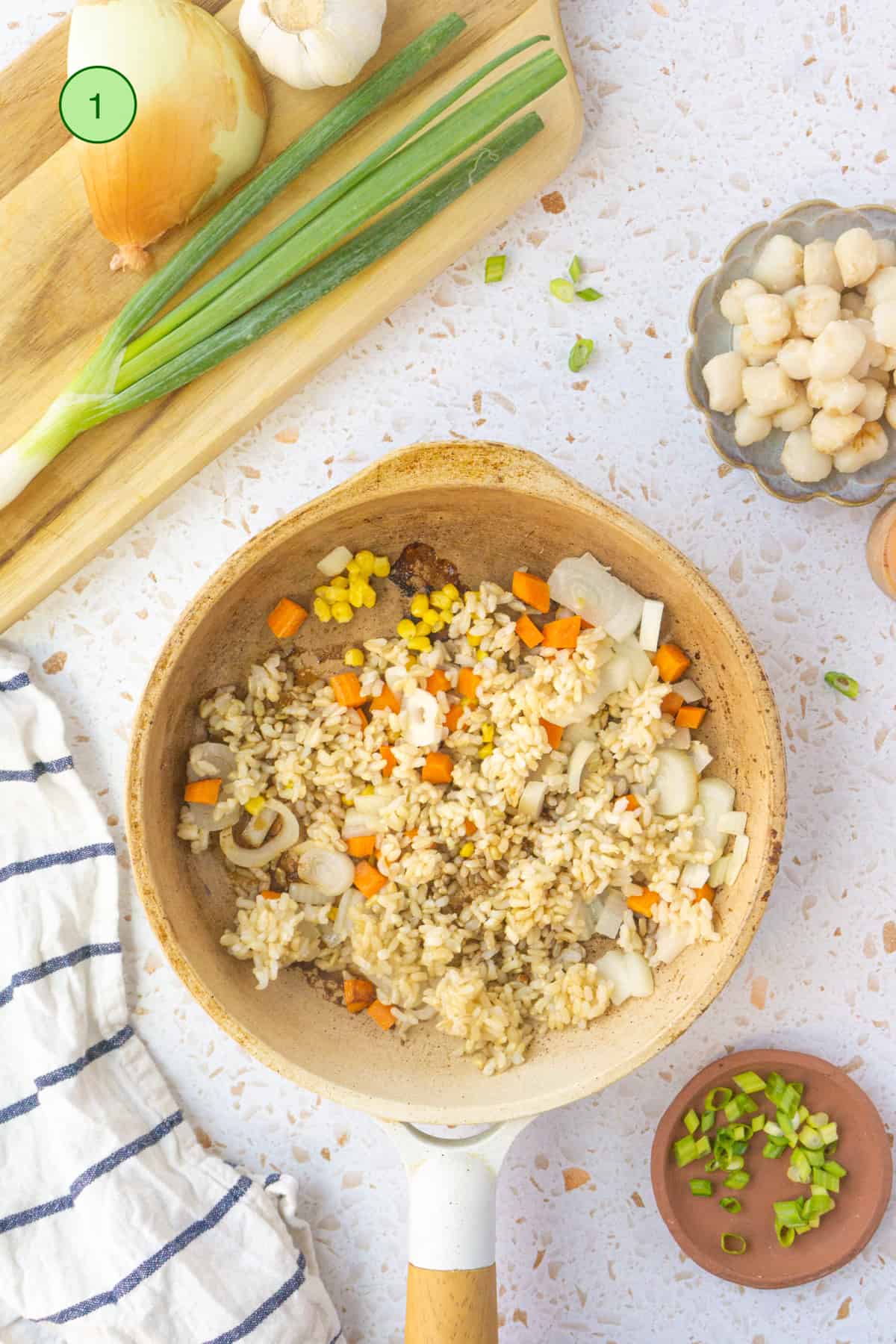 Cooking the scallop fried rice in a skillet.
