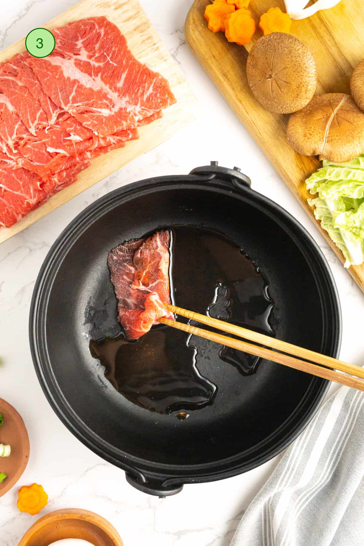 Cooking the beef slices in a cast iron pot.
