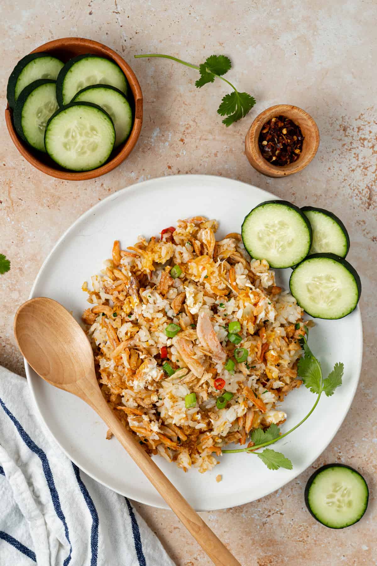A bowl of crab fried rice with a wooden spoon scooping some.