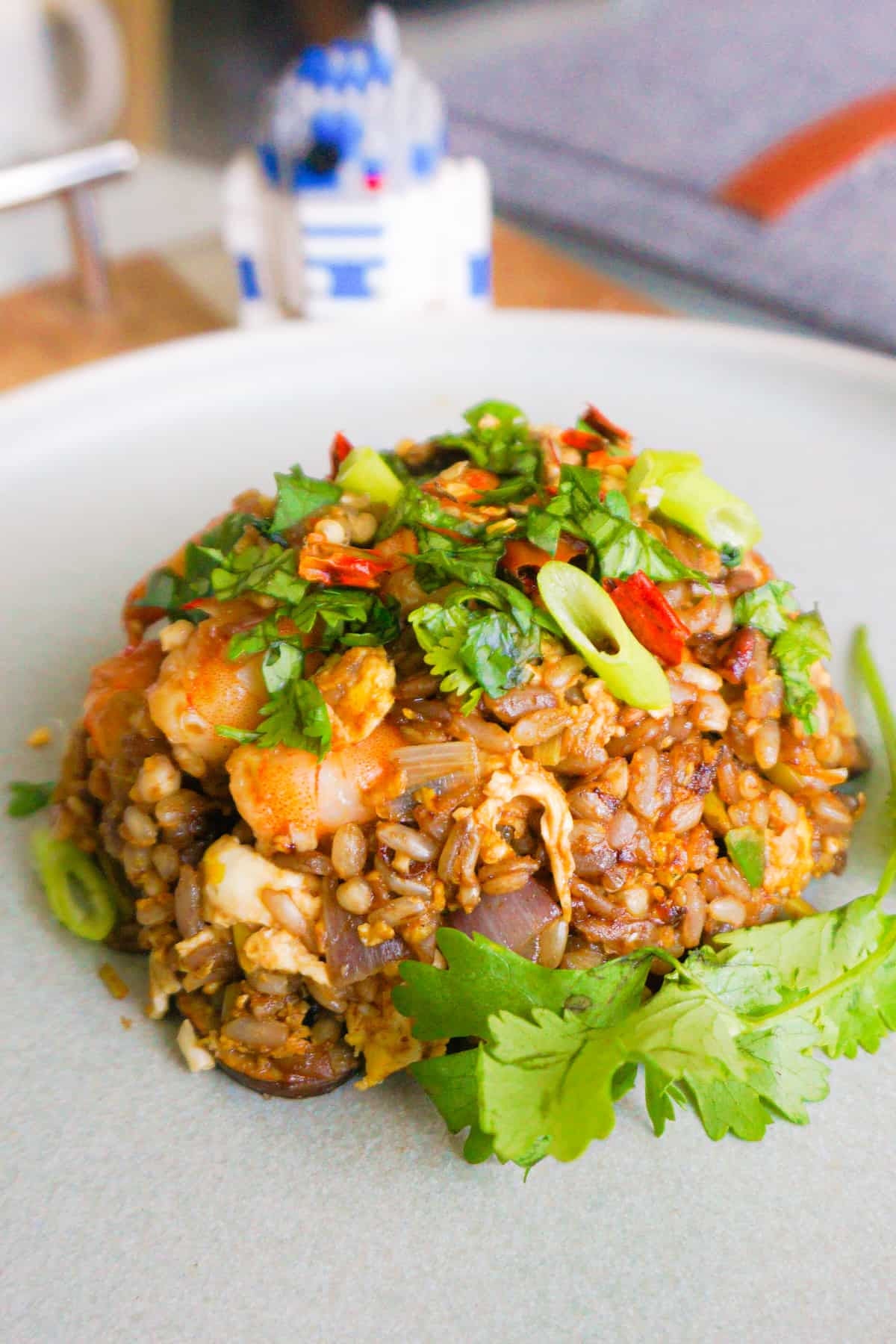 A mound of lemongrass fried rice garnished with scallions and cilantro.