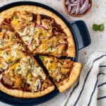 A slice of BBQ chicken pizza being servied.
