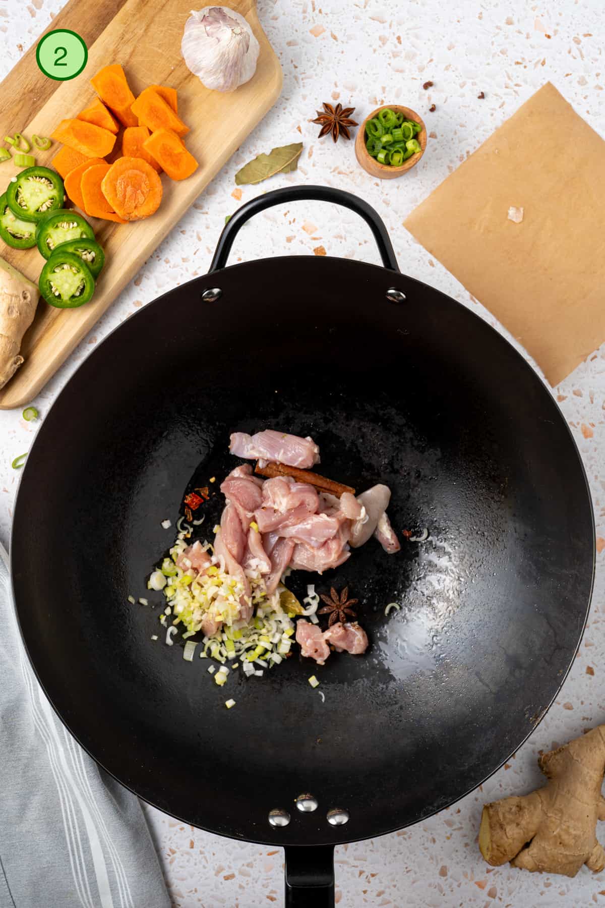 Sauté the aromatics and chicken in the wok.