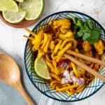 A bowl of khao soi with chopsticks twirling the noodles.